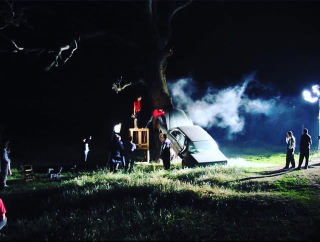 Night exterior with a car and atmospheric set lighting