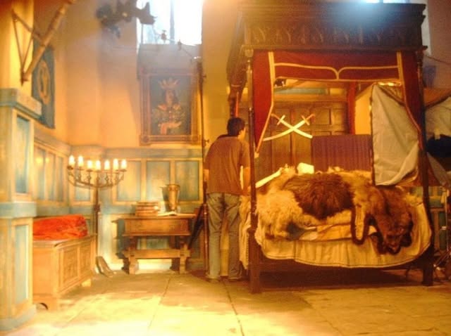 Period interior set with a bed, textiles and warm light